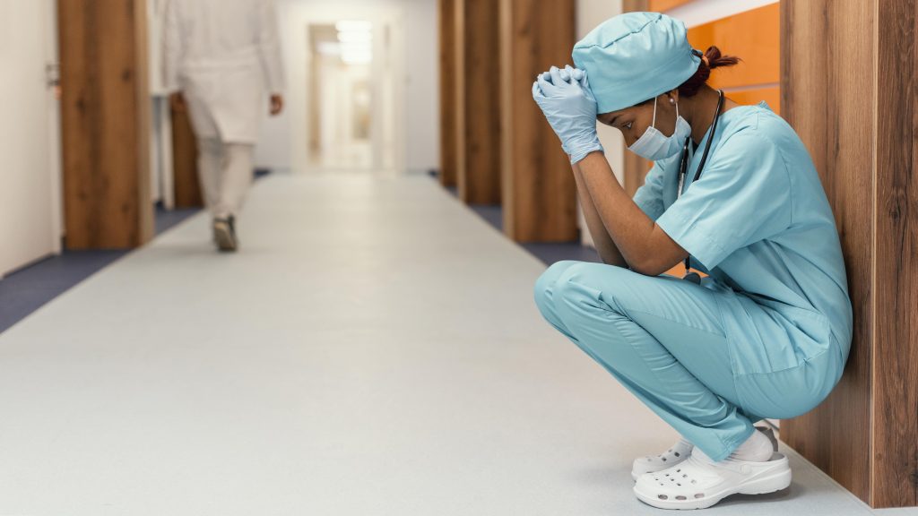 Full-shot-tired-health-worker-sitting (1)