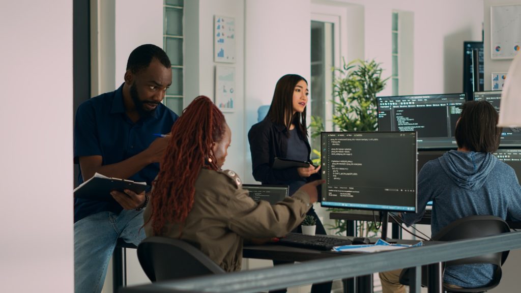 A development team discussing code on screen while reviewing a software build